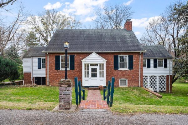 A brick home with a brick walkway leading up to the front door in the center. I light post and bright green front yard. A home situated in a highly sought after Louisville Neighborhood